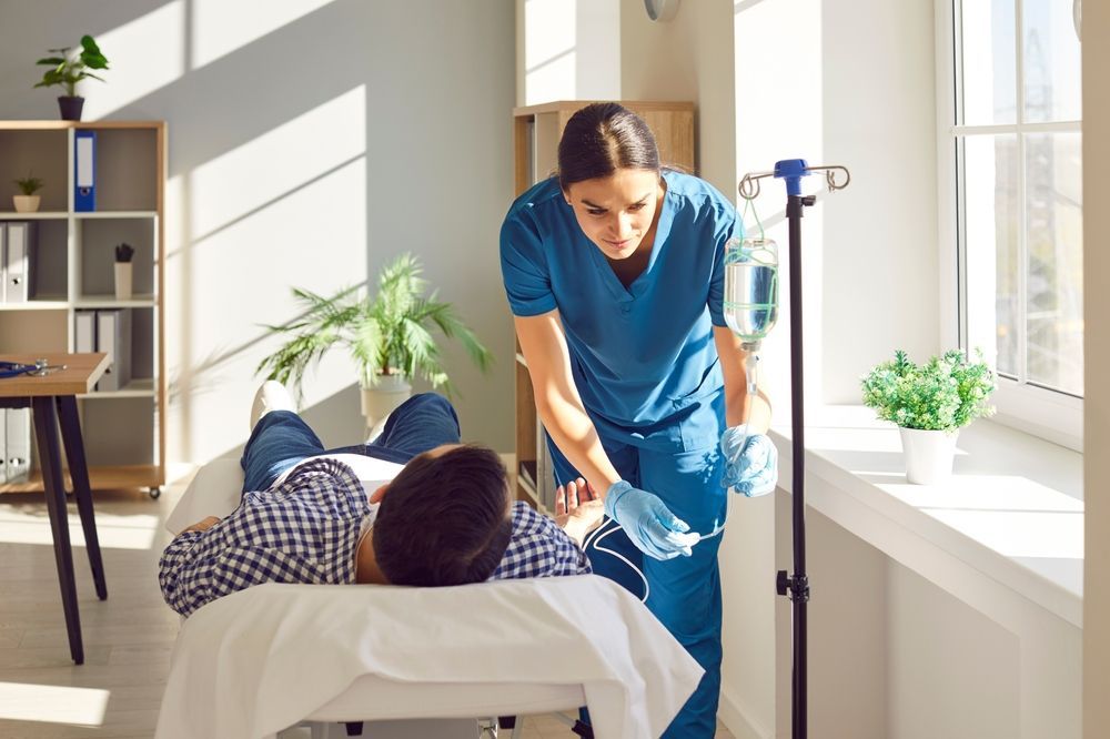 A nurse is standing next to a patient in a hospital bed.