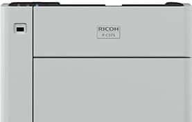 A white ricoh printer is sitting on a white surface.