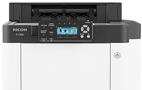 A ricoh printer is sitting on top of a white table.