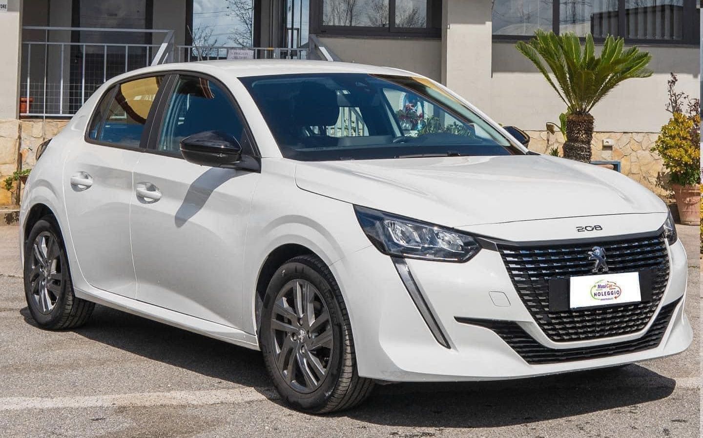 Un'auto bianca è parcheggiata davanti a un edificio.