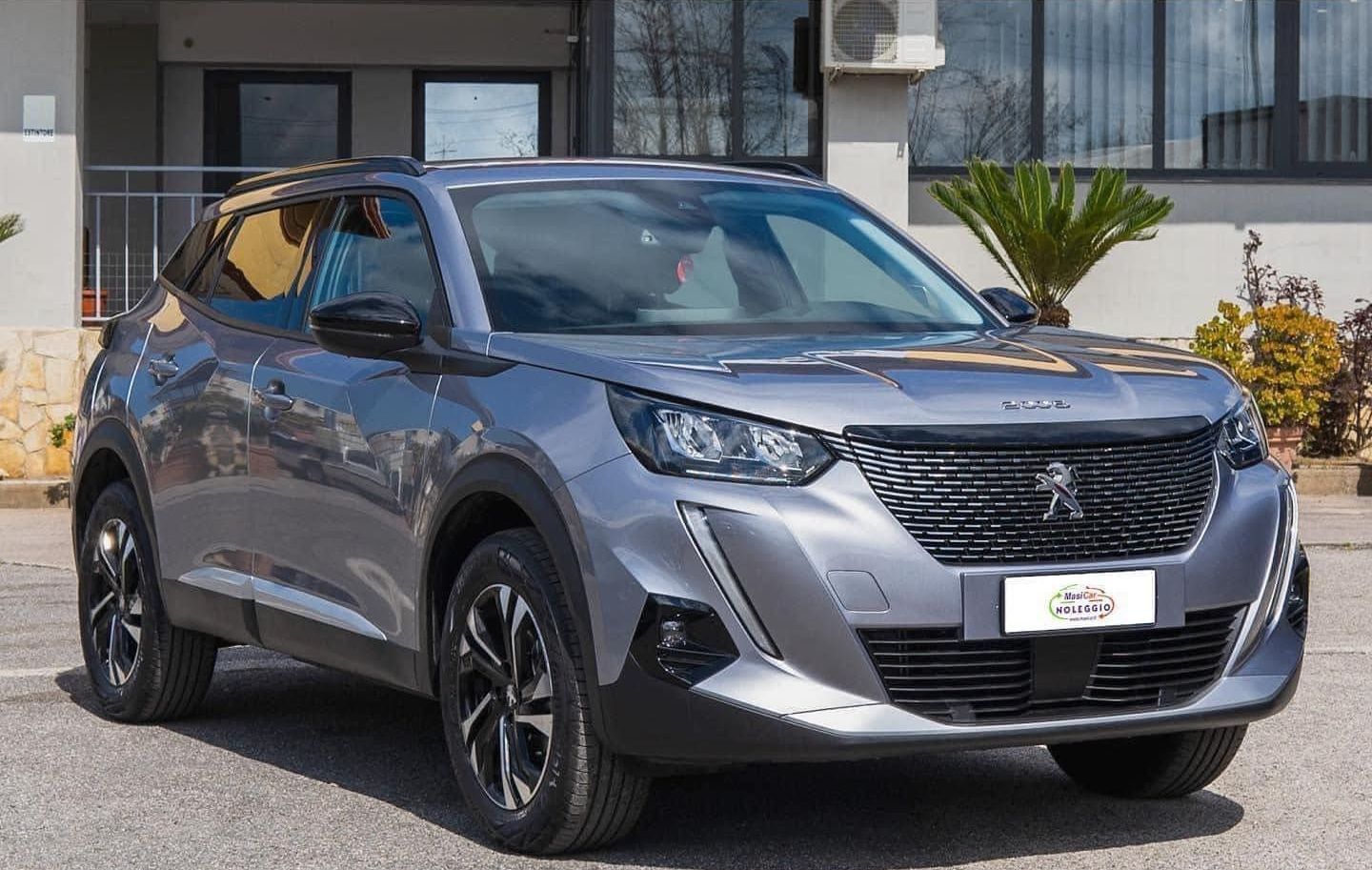 Una peugeot 2008 è parcheggiata davanti a un edificio.