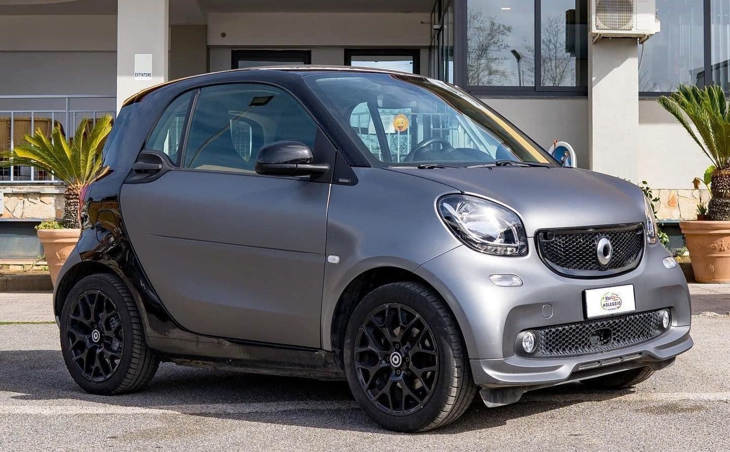 Un'auto intelligente è parcheggiata davanti a un edificio.