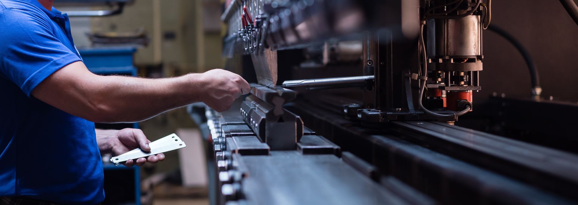 Worker in blue shirt operating machinery on an industrial factory line