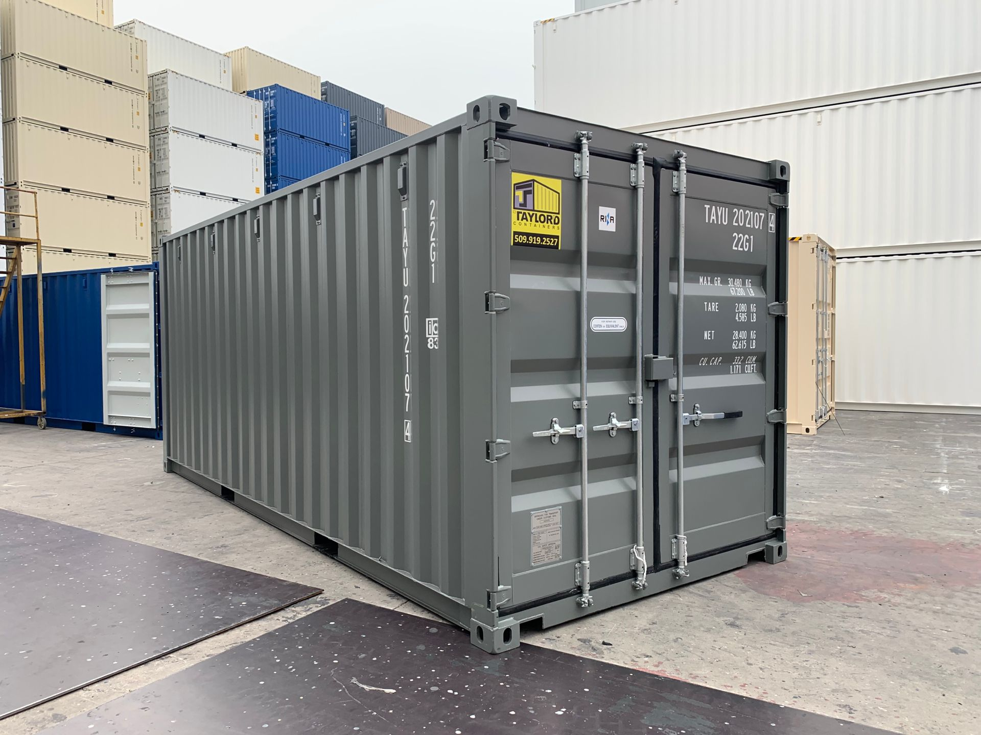 A large gray shipping container is sitting in a parking lot.
