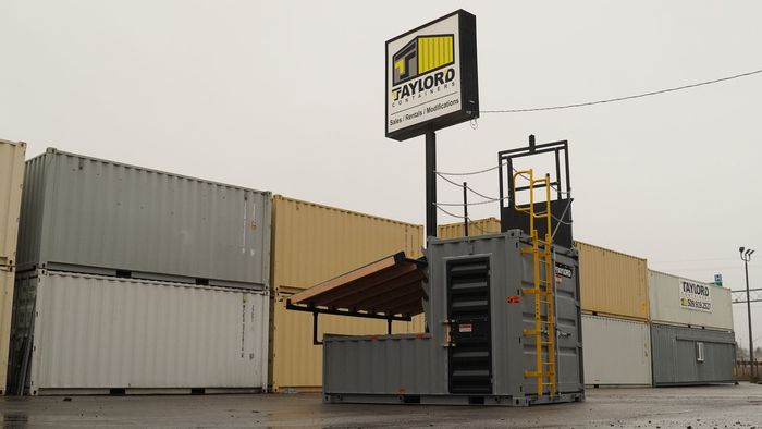 A stack of shipping containers in front of a building with a sign that says ' xtreme ' on it