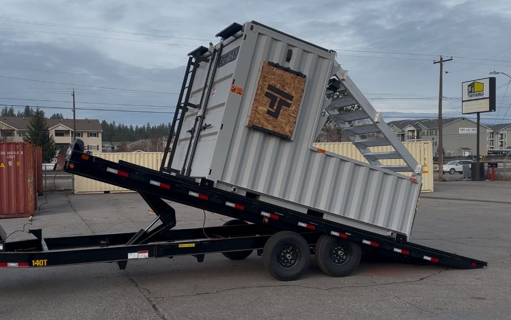 A shipping container is sitting on top of a trailer.
