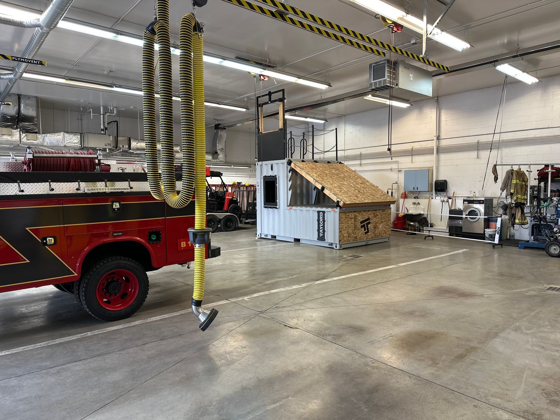 A red fire truck is parked inside of a garage