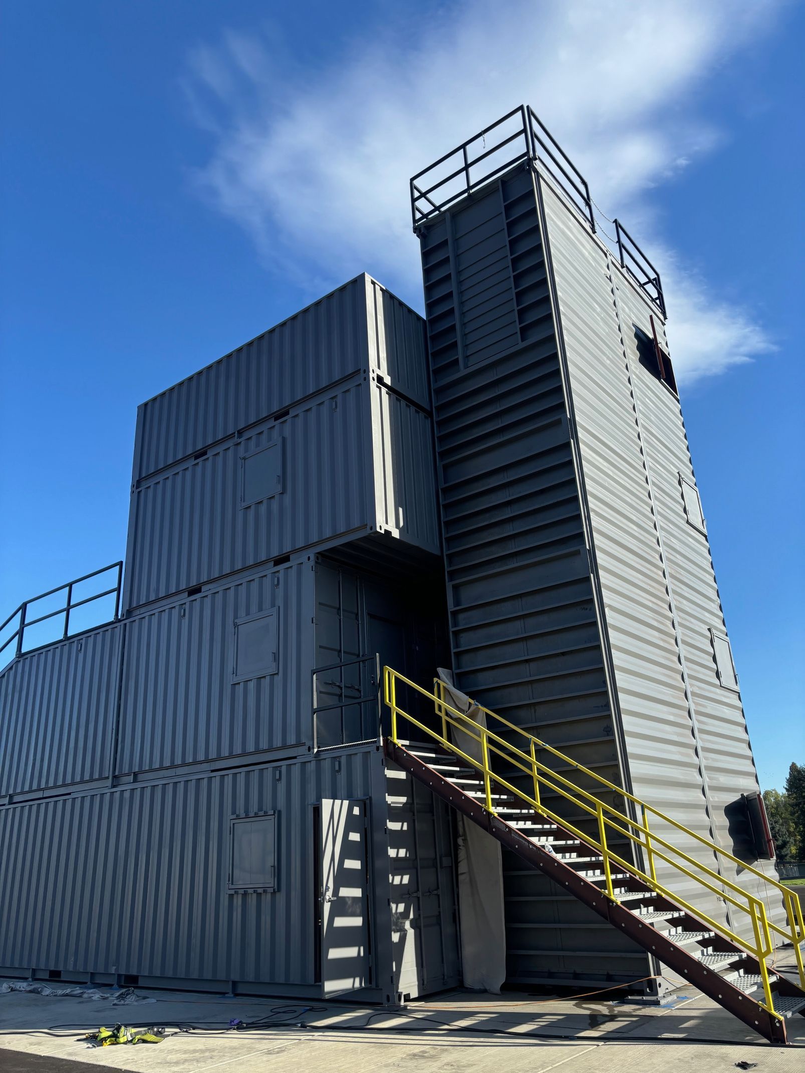 A building made out of shipping containers with stairs leading up to it.
