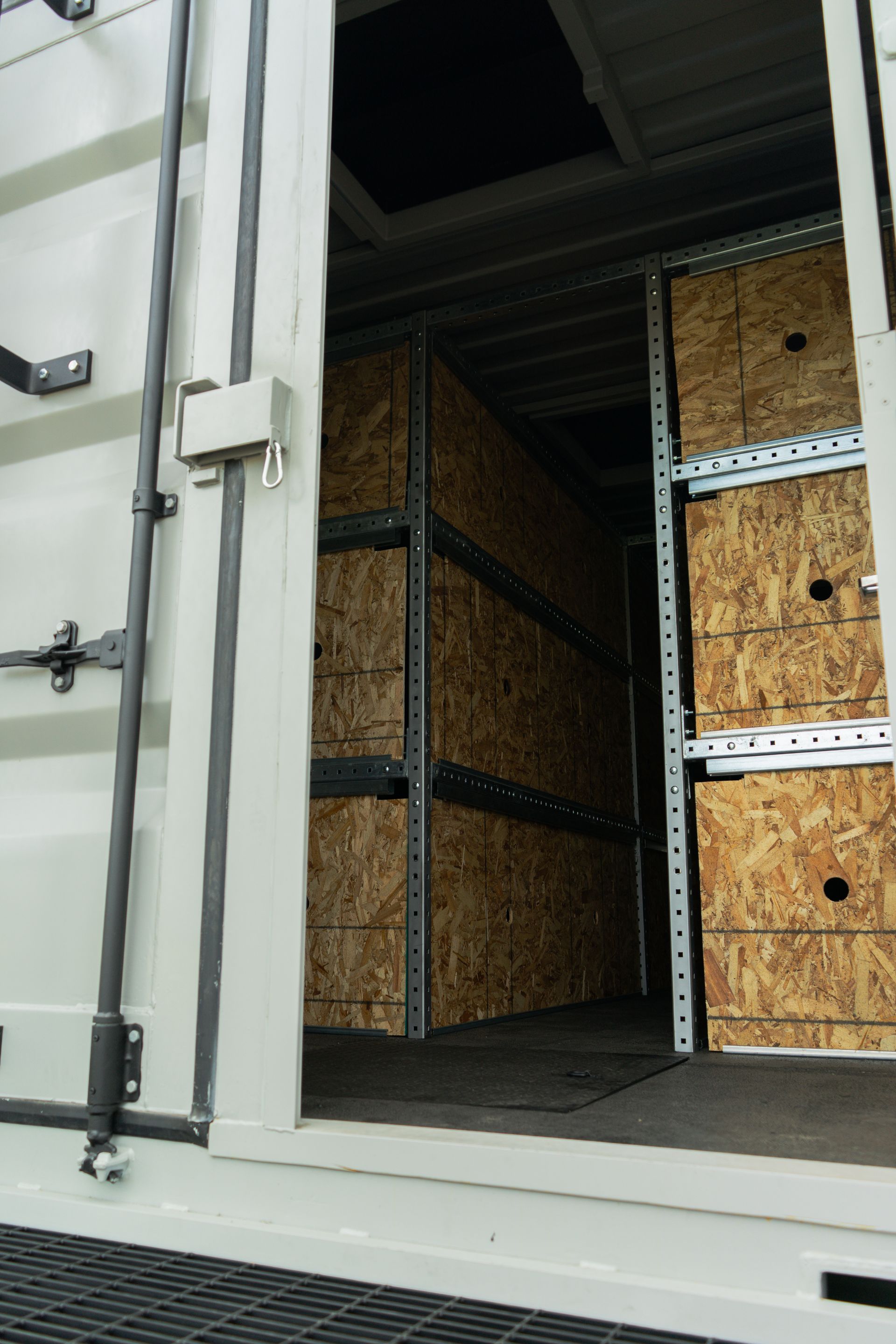 Looking through the doors of a shipping container with OSB inside