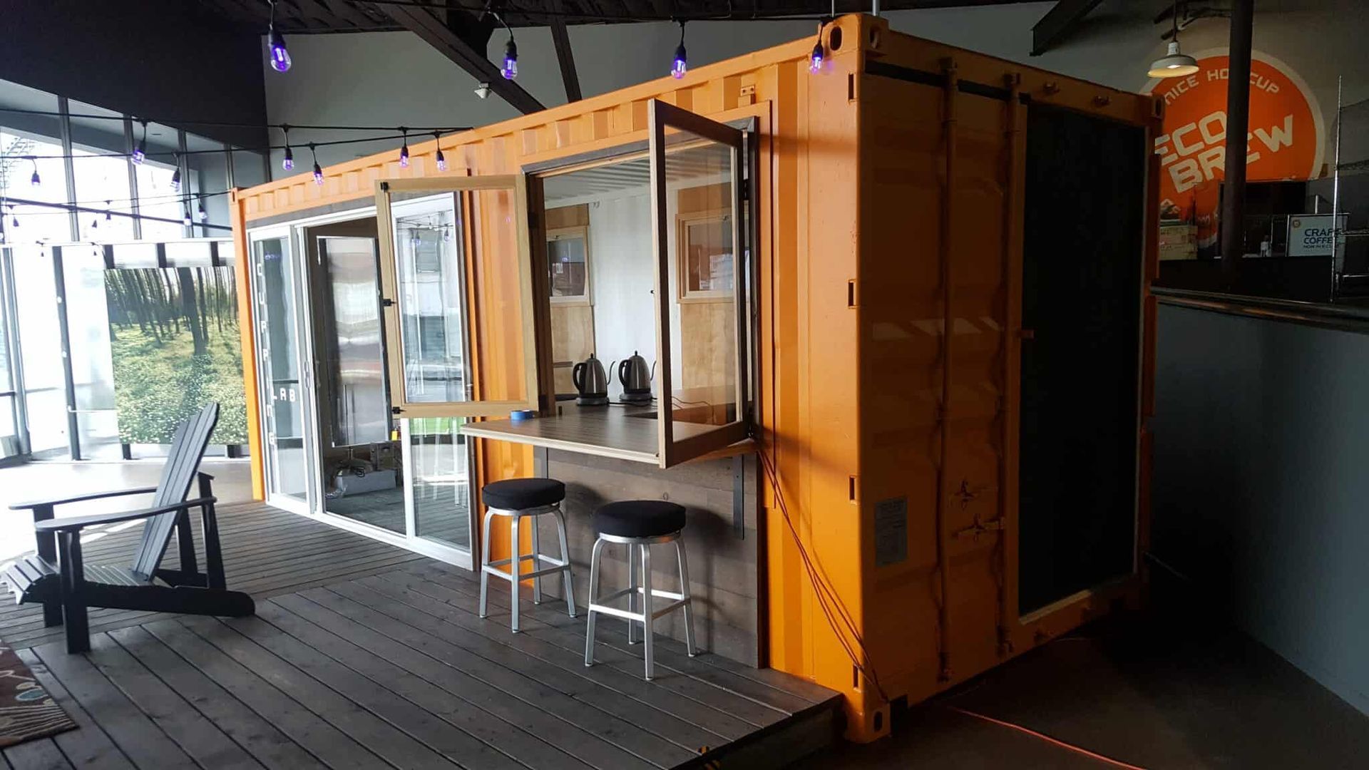 A large orange shipping container is being used as a restaurant.