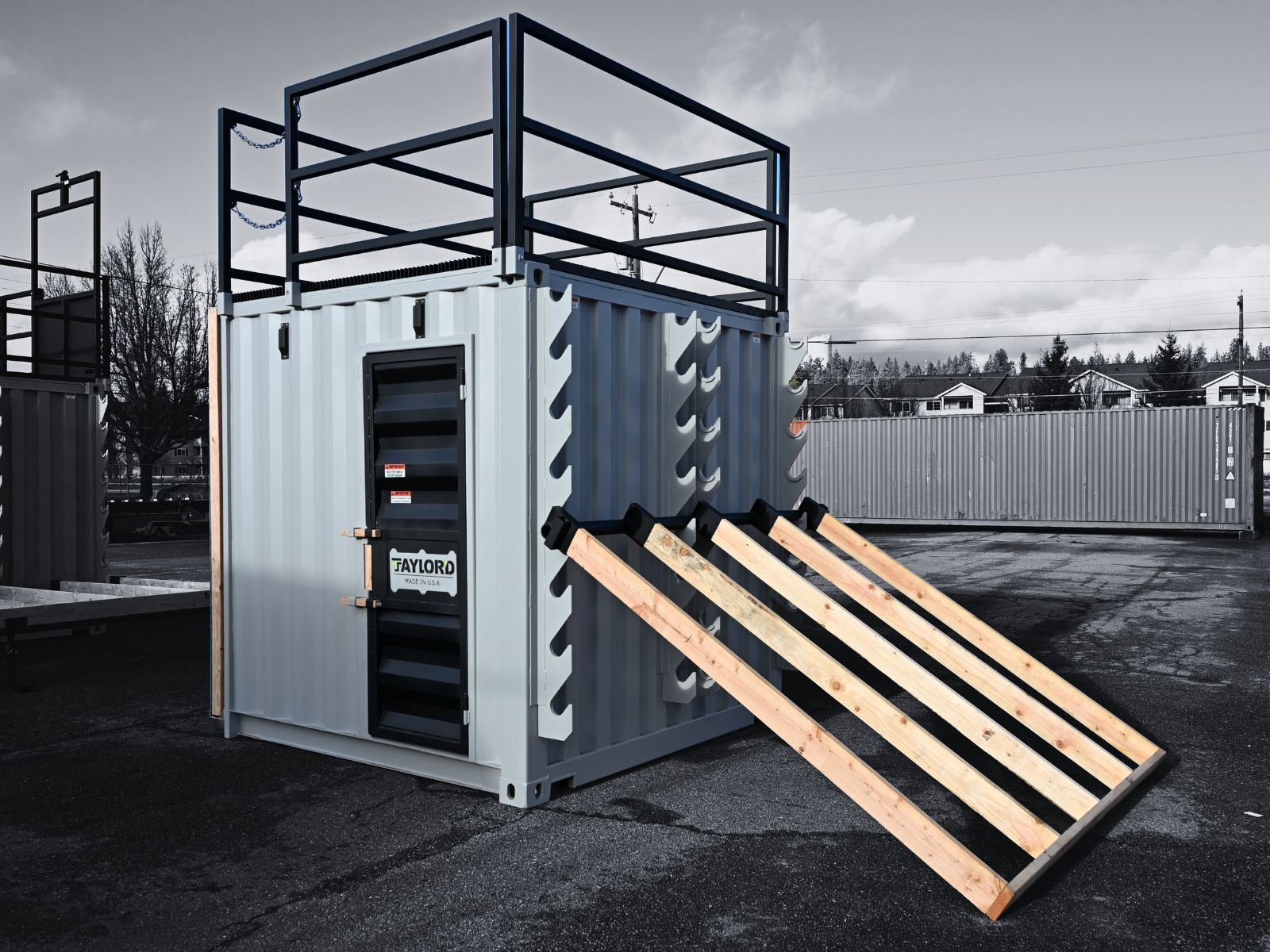 Modified shipping container with a ramp, and a platform on top.