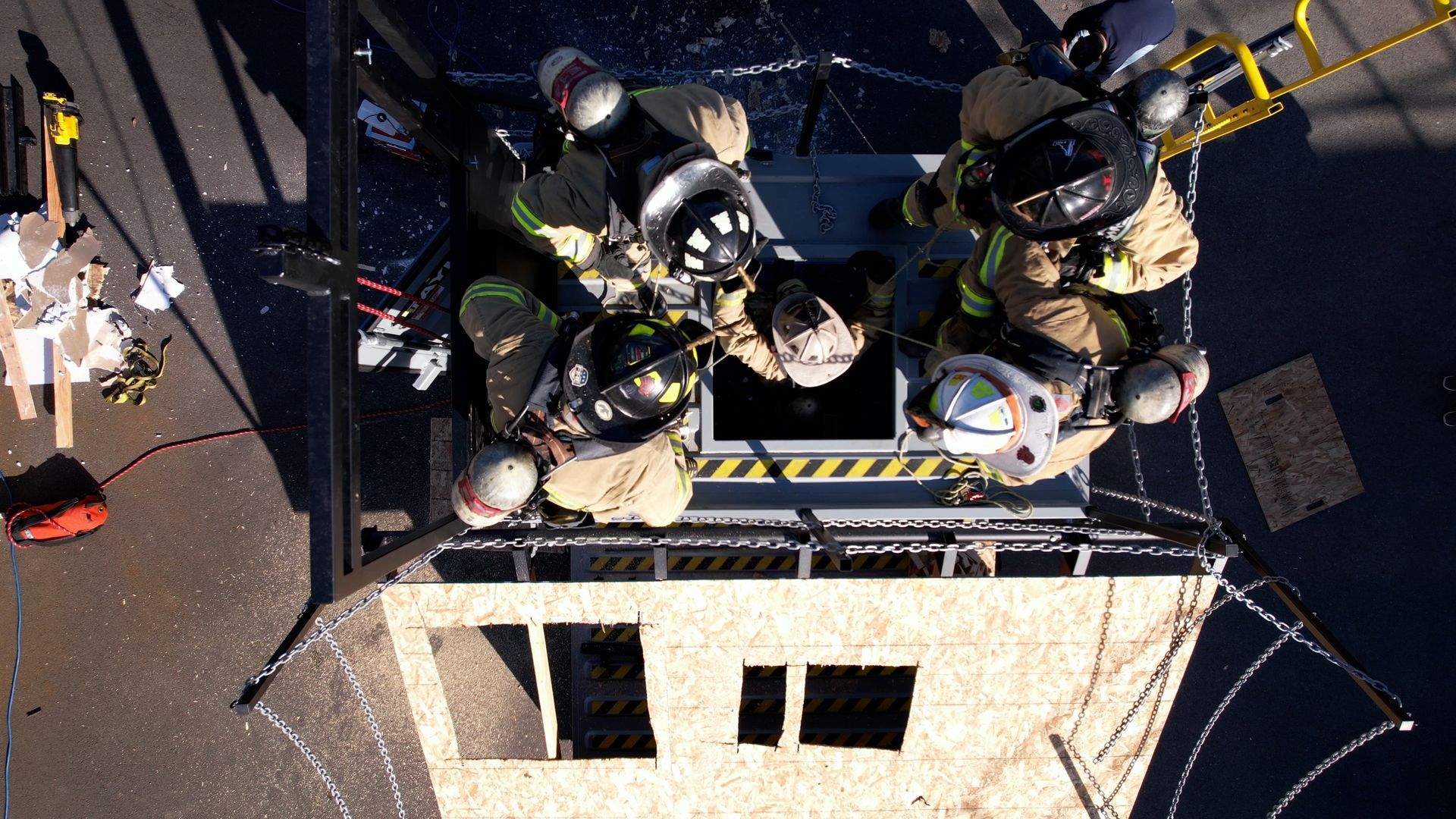 An aerial view of a group of firefighters on top of a building