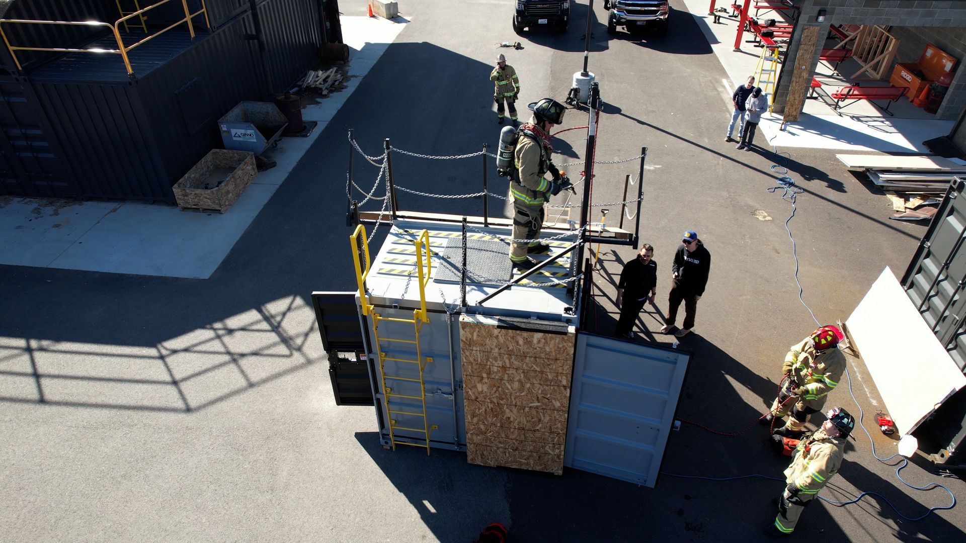 An aerial view of a group of firefighters standing around a box.