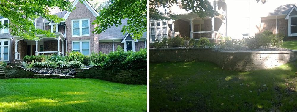 A large brick house with green lawn in front, trees overhead.