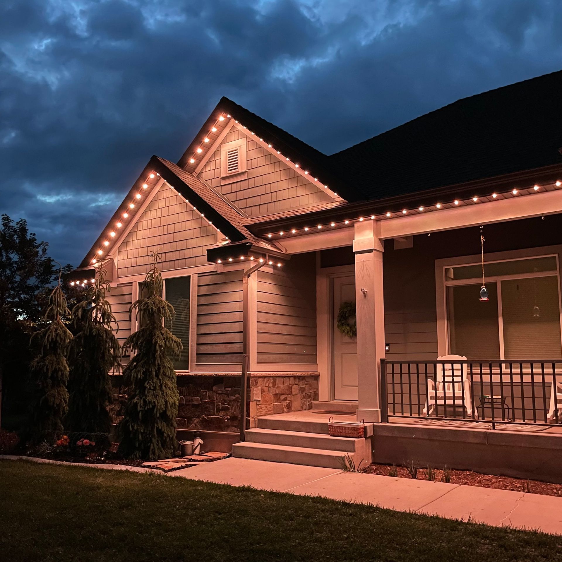 A house with a porch and stairs is lit up at night