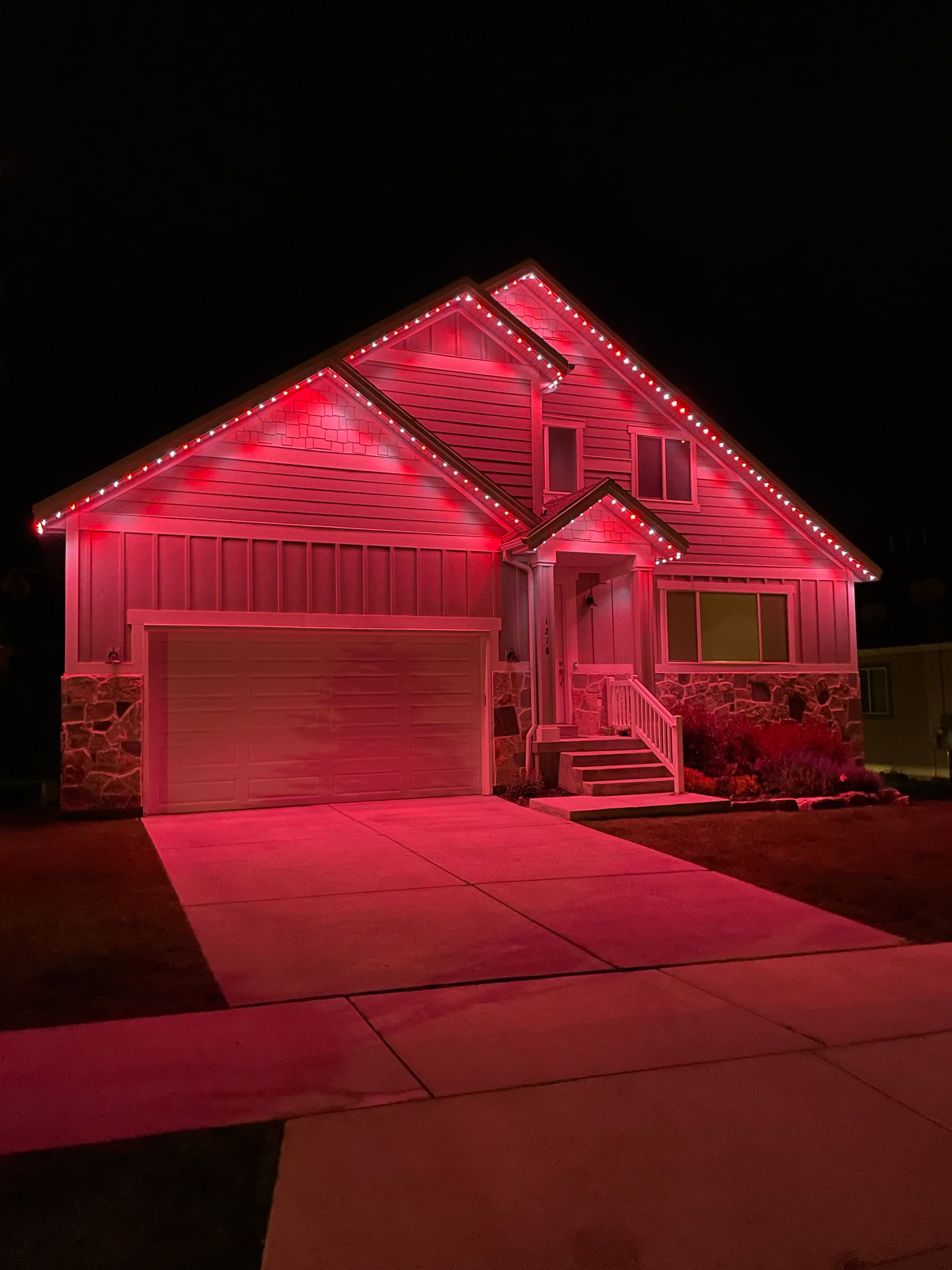 A house is lit up with red lights at night.