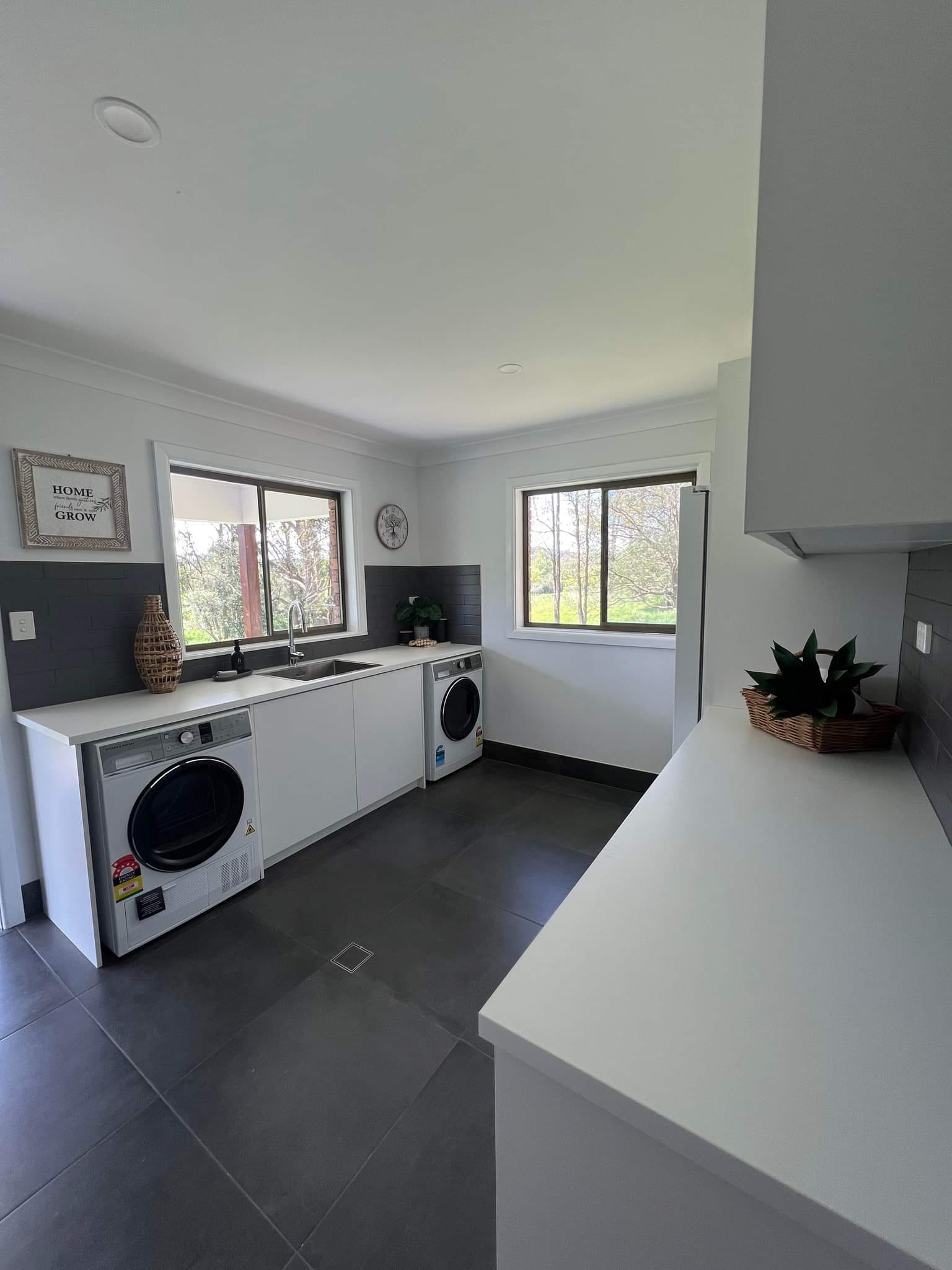 A laundry room with a washer and dryer and a sink.