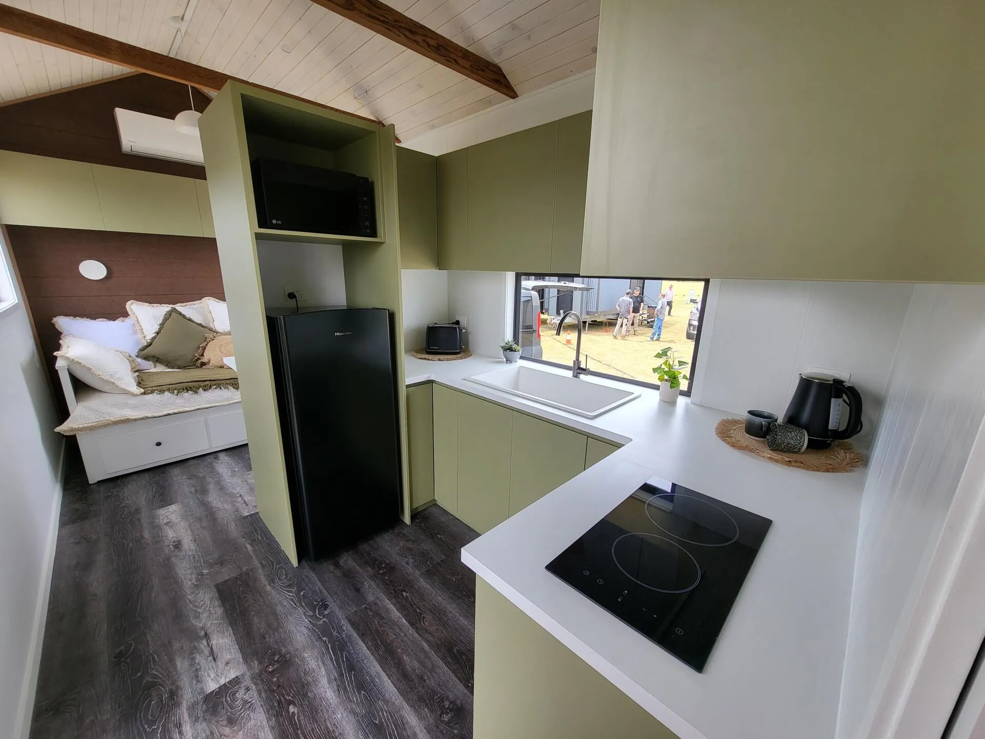 A kitchen with a refrigerator , sink , and stove top oven.