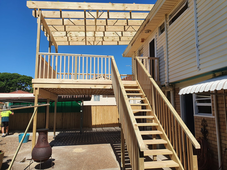 A wooden deck with stairs leading up to it