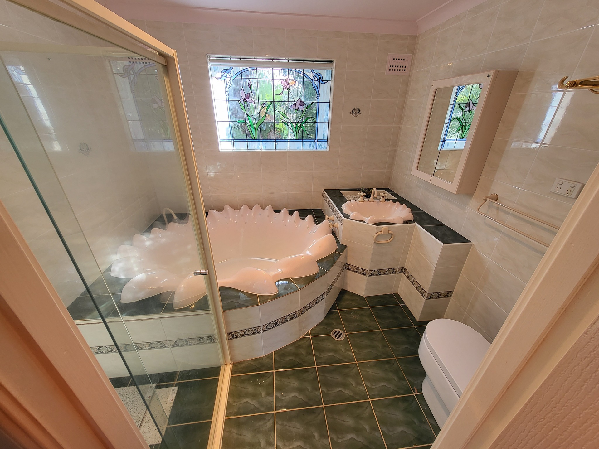 A bathroom with a tub , sink , toilet and mirror.