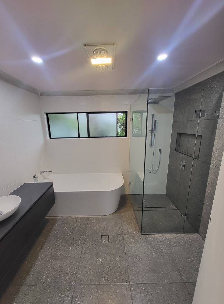 A bathroom with a bathtub , sink , and walk in shower.