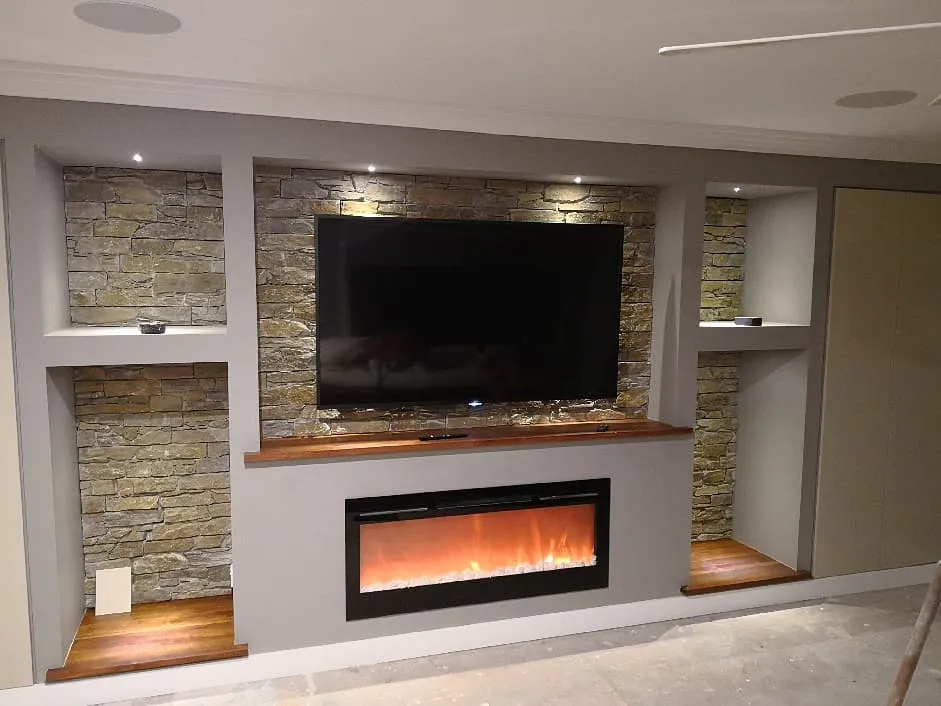 A living room with a fireplace and a flat screen tv