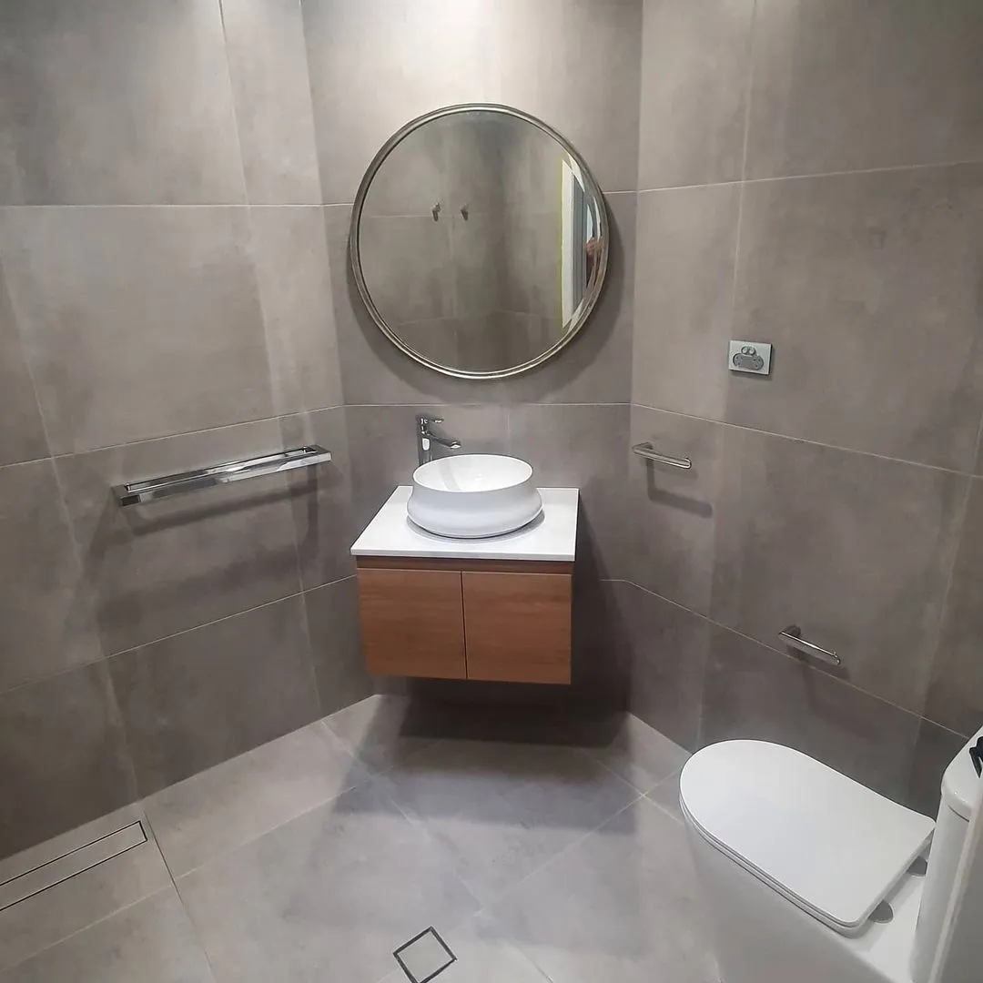 A bathroom with a toilet , sink and mirror