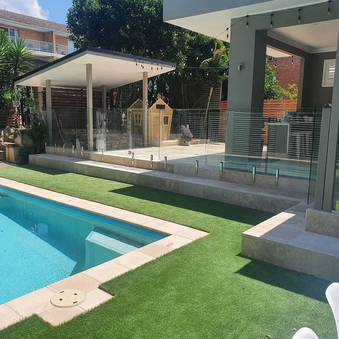 There is a large swimming pool in the backyard of a house.