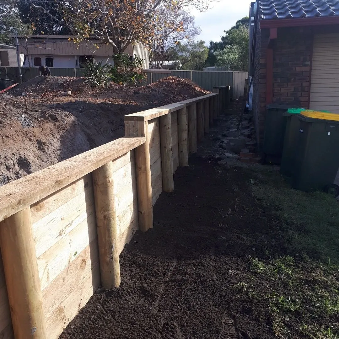 A wooden fence is being built in front of a house.