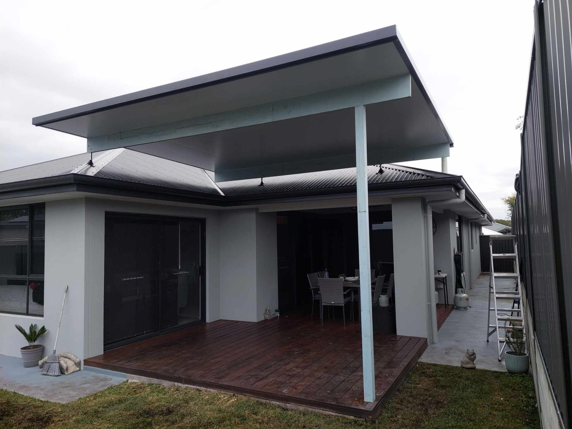 A white house with a covered patio in the backyard.