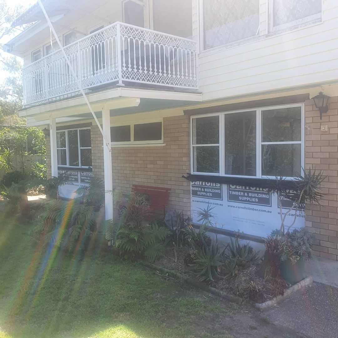 A large brick house with a balcony and lots of windows.