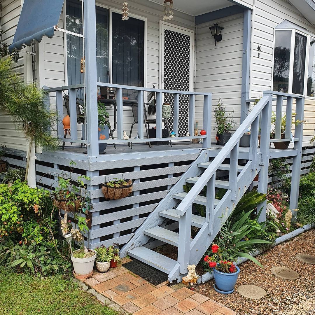 A white house with a blue porch and stairs