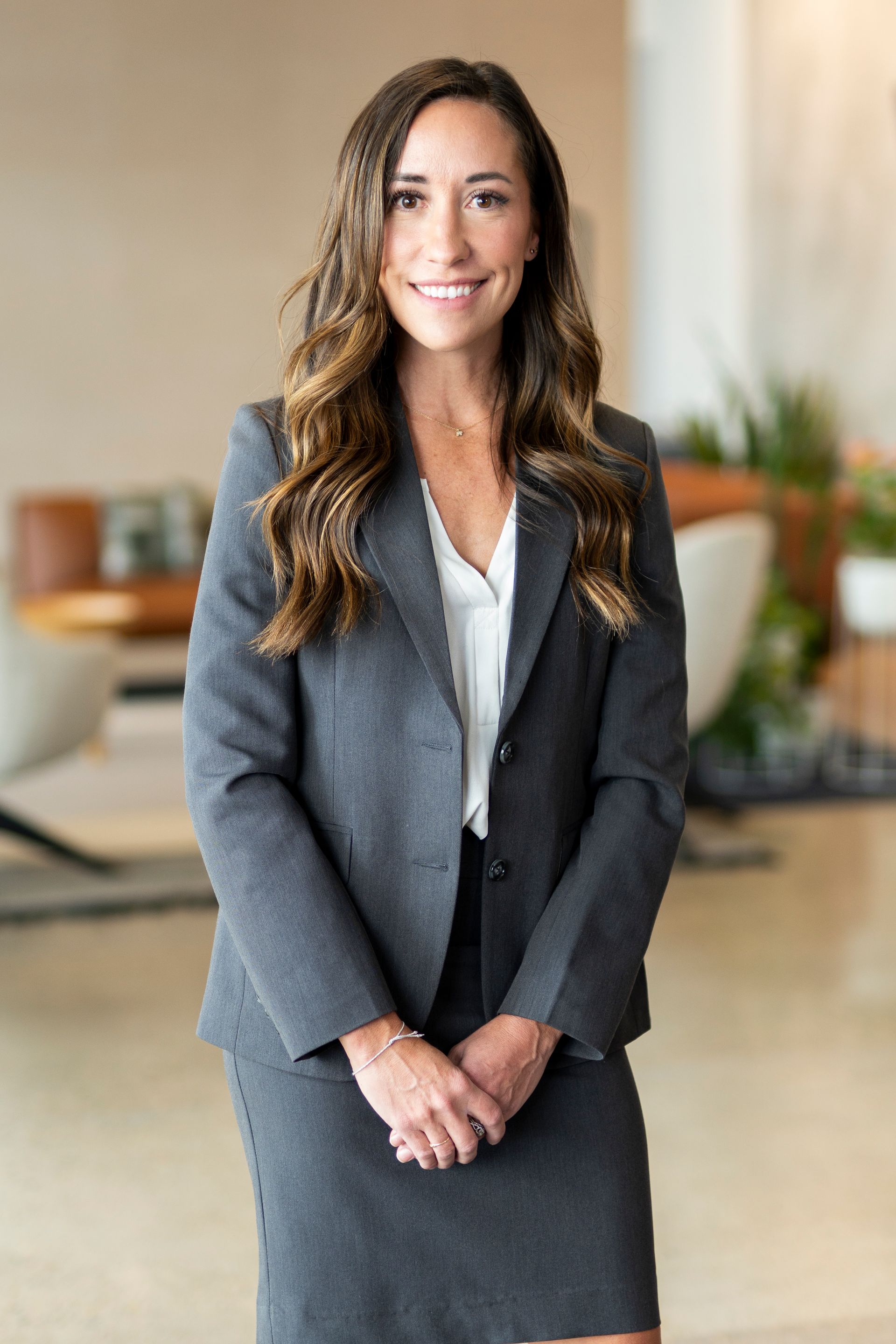 A woman in a white shirt is smiling for the camera.