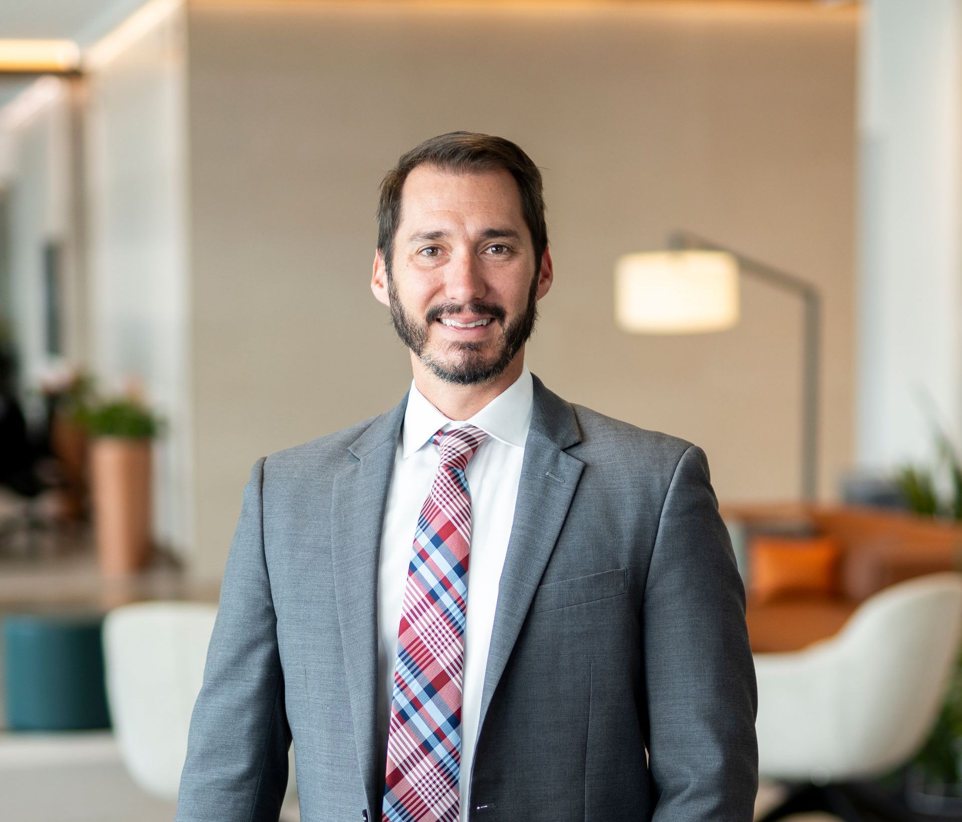 A man in a suit and tie is smiling for the camera.