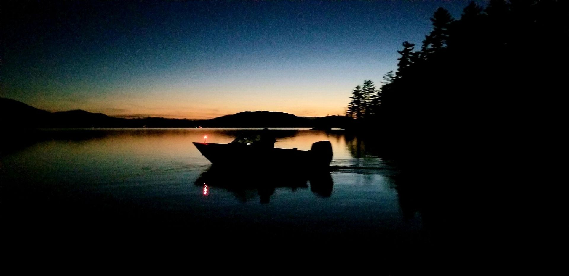 A boat is floating on a lake at night.