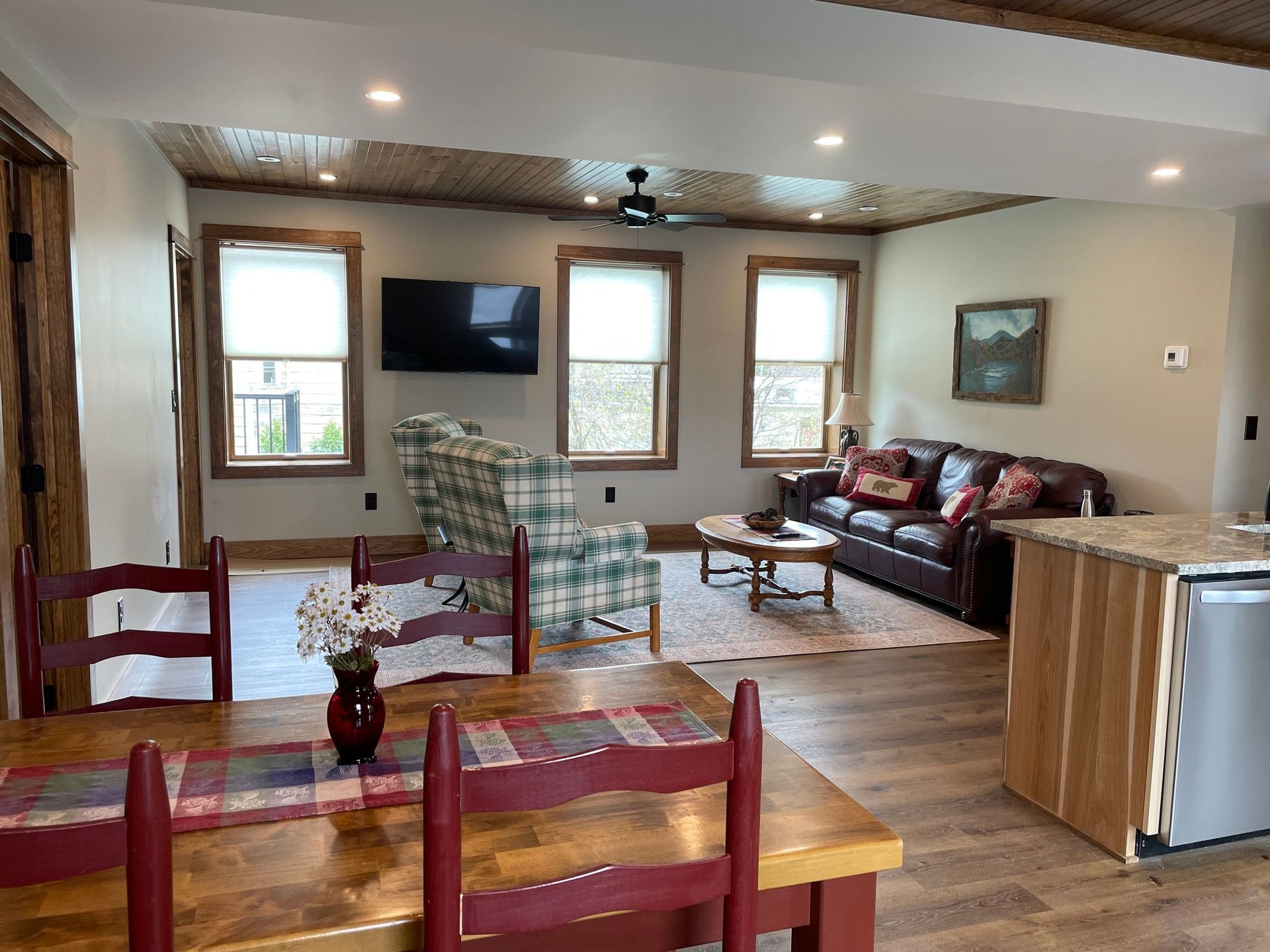 A living room with a couch , chair , table and television.