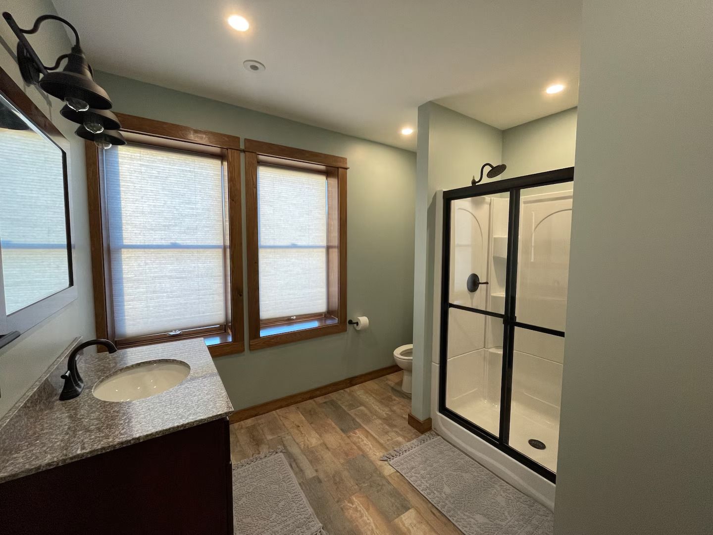 A bathroom with a sink , toilet and shower.