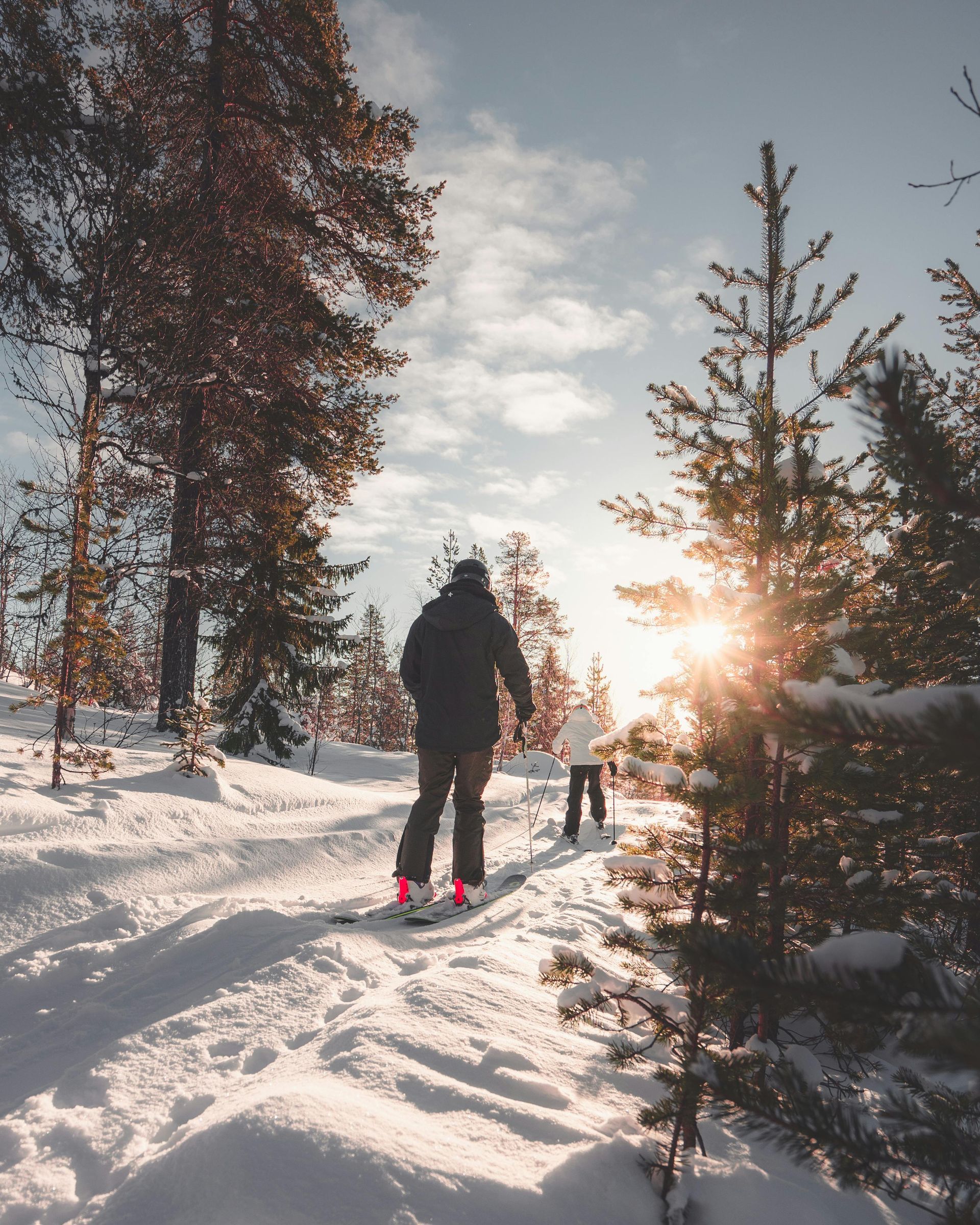 A person is skiing down a snowy path in the woods.
