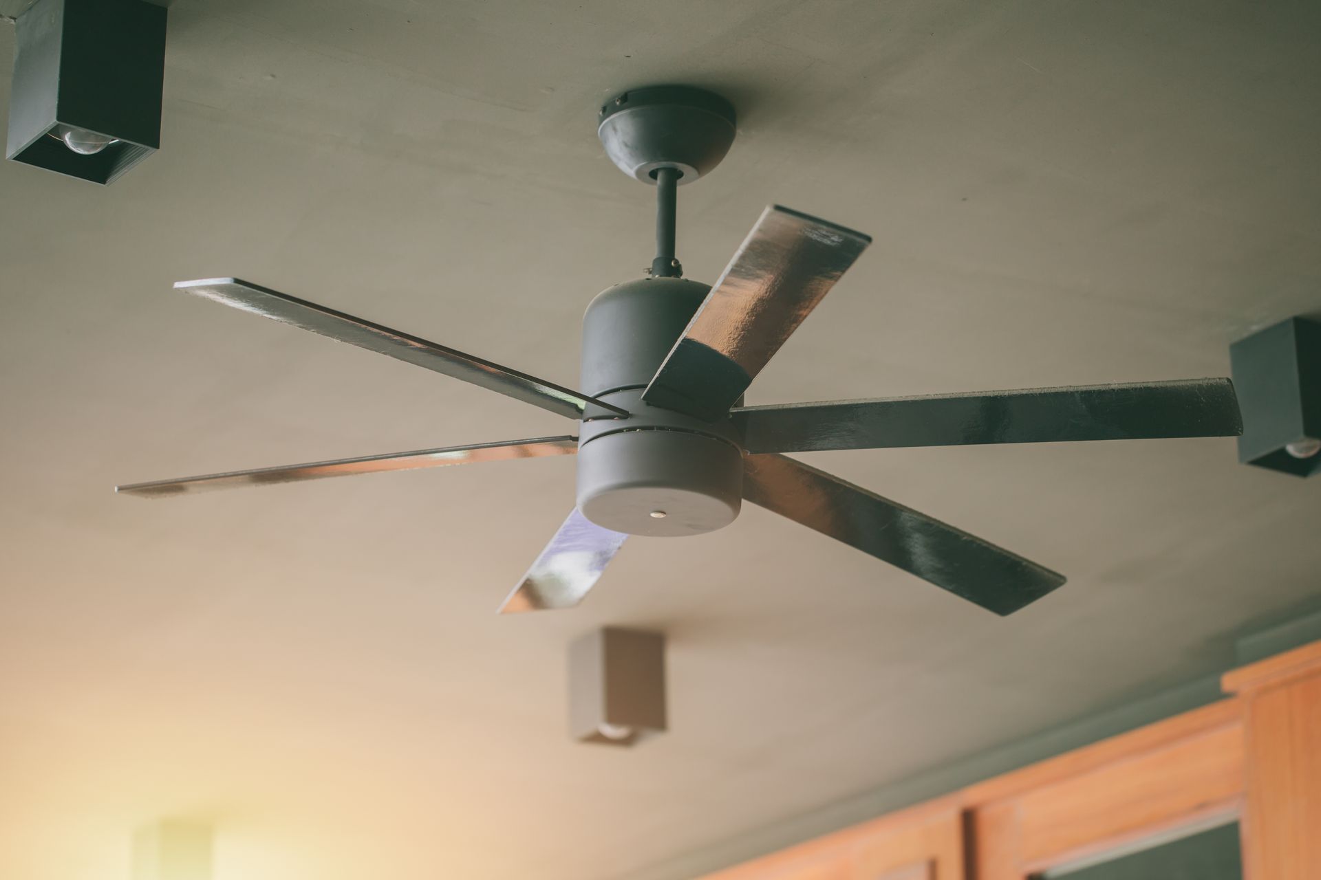 a ceiling fan is hanging from the ceiling in a kitchen .