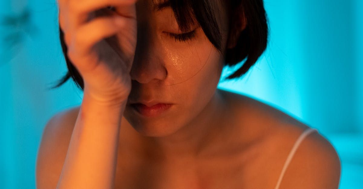 A woman is crying and covering her face with her hand.