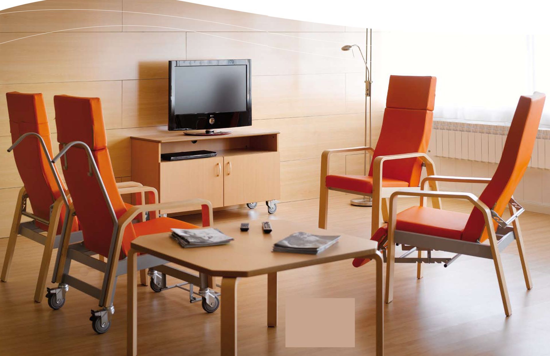 Una sala de estar con sillas, una mesa y un televisor de pantalla plana