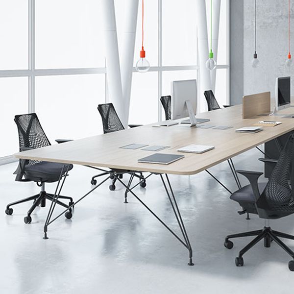 Una sala de conferencias con una larga mesa y sillas de madera