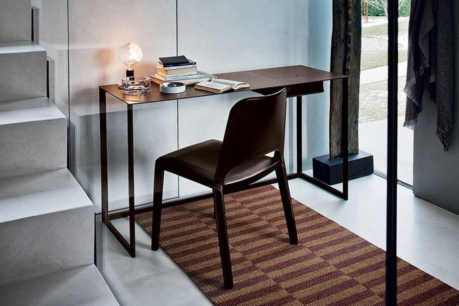 Un escritorio y una silla en una habitación con escaleras