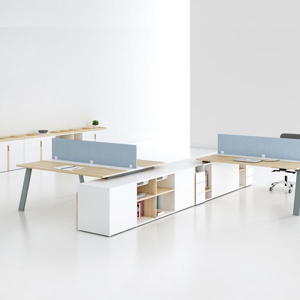 Una fila de escritorios con divisores azules en una oficina.