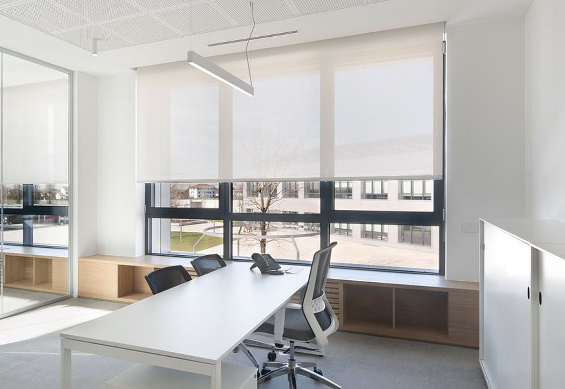Una habitación con una mesa y sillas frente a una ventana