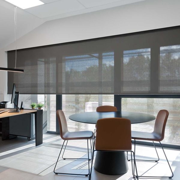 Una habitación con una mesa y sillas frente a una ventana