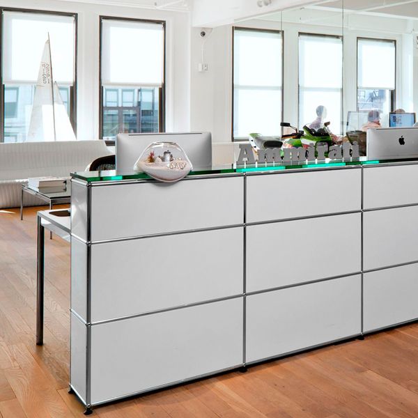 Un escritorio blanco con tapa de cristal en una habitación