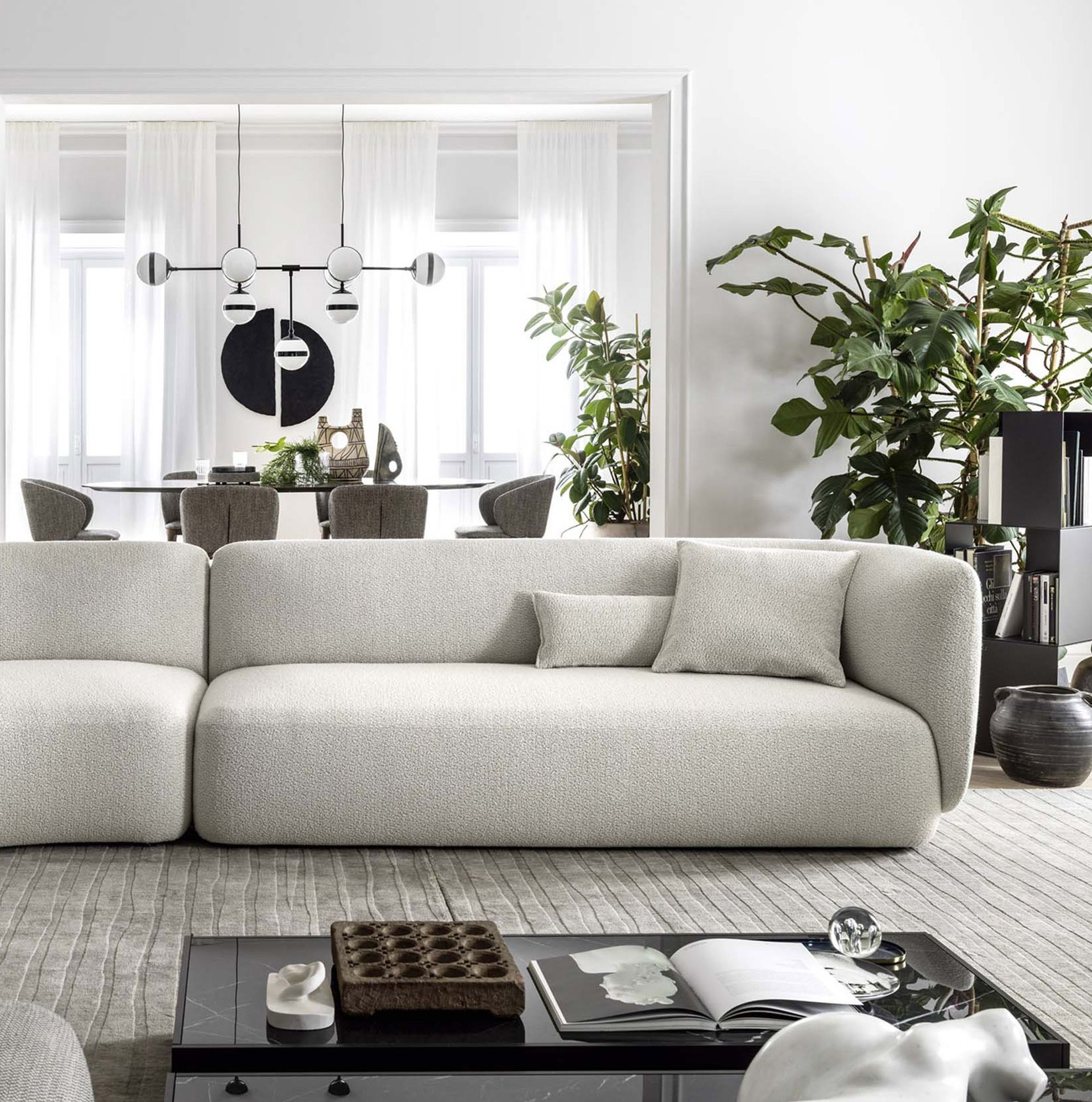 Una cama con sábanas blancas y almohadas al lado de una mesa de noche