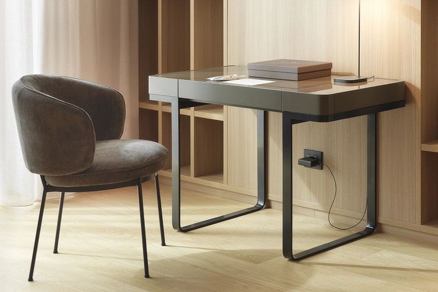 Un escritorio y una silla en una habitación con escaleras