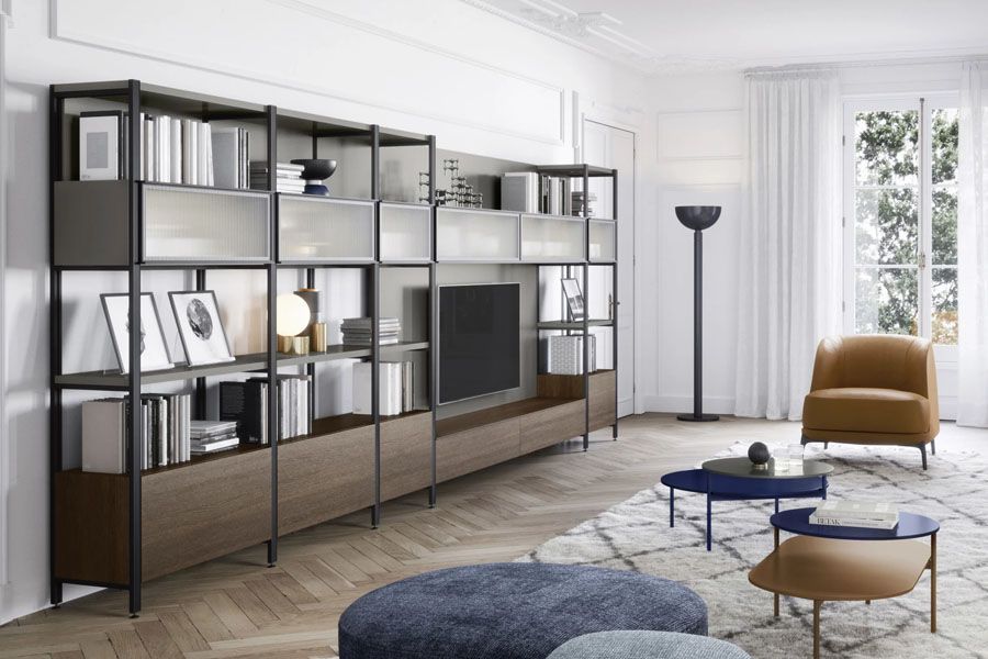 Una cama con sábanas blancas y almohadas al lado de una mesa de noche